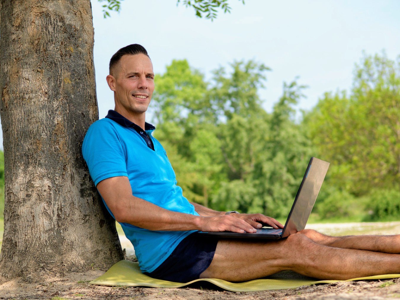 Christian Roller arbeitet draußen am Laptop