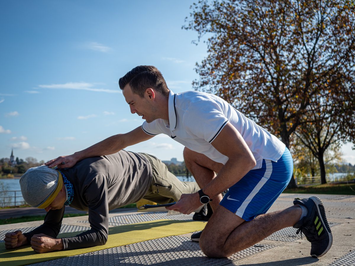 Christian Roller korrigiert im 1:1-Training draußen die Haltung im Nacken- und Schulterbereich