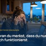 Dauerstress erkennen: Frau sitzt früh morgens telefonierend am Küchentisch, Stirn in der Hand, vor ihr Laptop und Brotdose