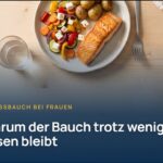 Stressbauch bei Frauen: Teller mit Lachs, Ofengemüse, Feta und Kartoffeln von oben auf einem Holztisch
